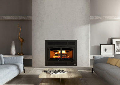 Stock photo of Osburn Horizon wood fireplace with gray sofas on each side. Marble shelving has a stork and vase on the left and two pictures on the right. The coffee table has a checkerboard game on it.