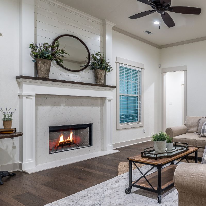 a mostly white living room with furniture and a fireplace